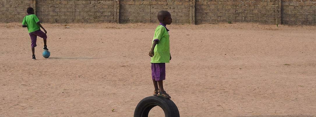 Niño jugando rueda escuela Gambia